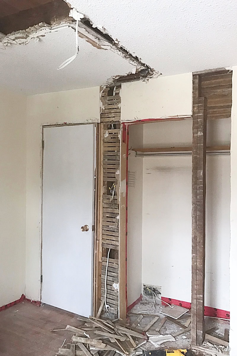 Bedroom with part of the wall opened to the lath and plaster