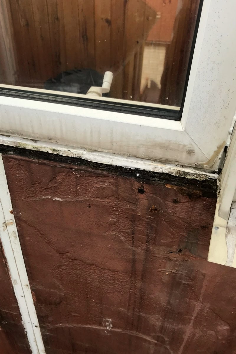 Damaged exterior window with visible leaks and mold